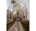 Widok na główną nawę kościoła p.w. Wniebowzięcia NMP w Drohiczynie. W głębi prezbiterium z ołtarzem głównym i bocznymi z bogatą dekoracją rzeźbiarską.